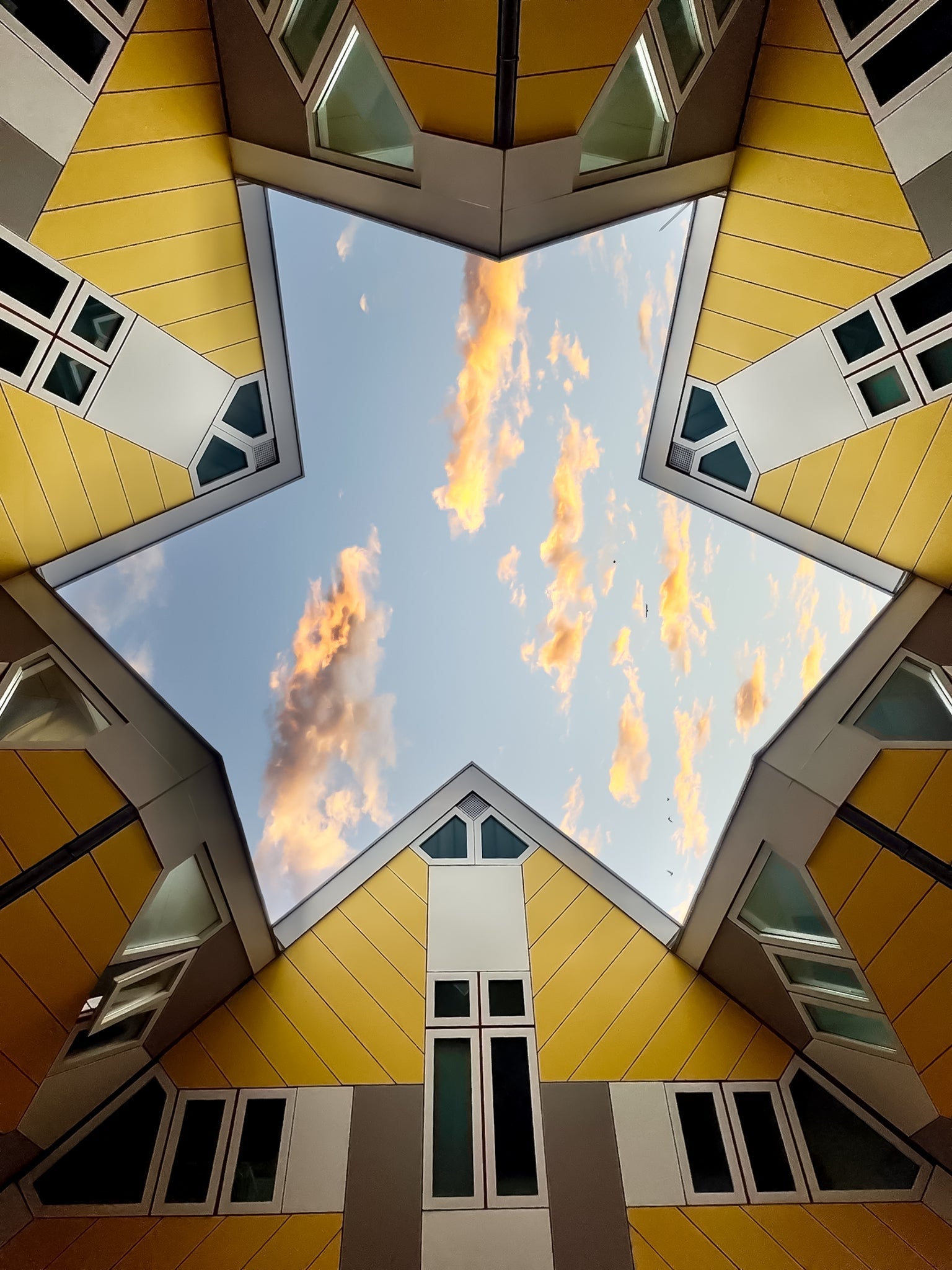 Upward view of Rotterdam cube houses forming geometric angles around the sky in a bold architectural composition.