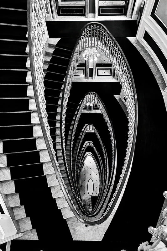 Dramatic staircase inside Hotel Bristol Palace in Genoa, Italy, with sweeping architectural lines and historic interior detail.