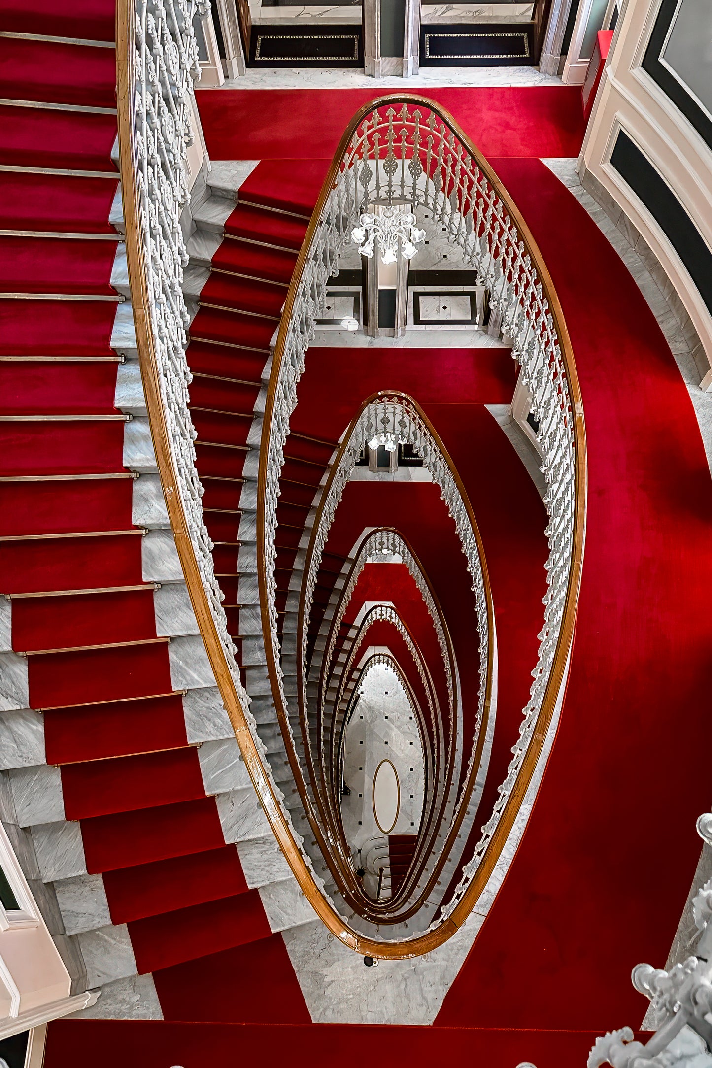 Dramatic staircase inside Hotel Bristol Palace in Genoa, Italy, with sweeping architectural lines and historic interior detail. 
